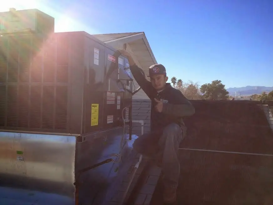 HVAC technician performing HVAC Inspection on a rooftop unit in Jamestown